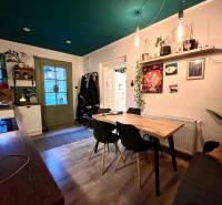 Dining room with a wooden table, houseplants, and a floor with a wooden decor in a family house.