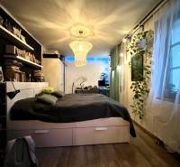 Bedroom in a family house with chandeliers, shelves, and a wooden decor floor.