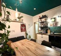 A family house kitchen with a wooden decor floor, green walls, and plants.