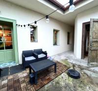 Entrance to the terrace of a family house in Komárno with garden furniture and lighting.