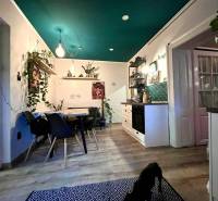 A kitchen in a family house with a wooden decor floor, a dining table, and plants.