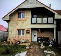 Family house on Hlavná Street in Vlčany, with a bicycle and a motorcycle in front of the entrance.
