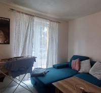 A bright living room with a sofa and a drying rack in a 2-room apartment.