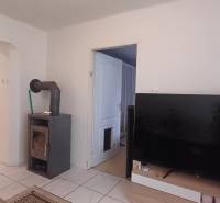 Interior of a 2-room apartment with a stove, television, and floor with wood decor.