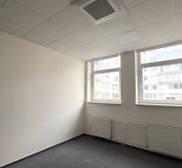 Office with carpet, white walls, and windows.