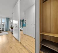 Interior of a 1-room apartment with a wooden decor floor, mirrored wardrobe, and modern furniture.