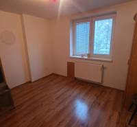A room in a 3-room apartment features a floor with a wooden decor, wardrobes, and a window with a radiator.