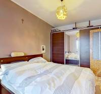 Bedroom in a 3-room apartment with a bed, nightstand, and built-in wardrobe.