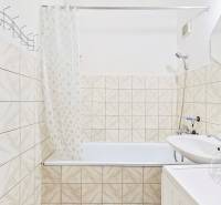 Bathroom in a 3-room apartment with a bathtub, shower, and tiled walls.