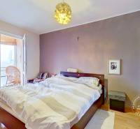 Bedroom in a 3-room apartment with a double bed, sliding wardrobe, and floor with wooden decor.