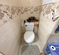 Bathroom in a 2-room apartment with decorative tiles and toilet equipment.