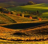 Hilly landscape in the Vráble area with agricultural and forest lands at dusk.