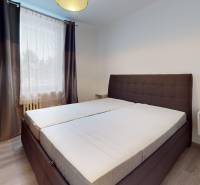 Bedroom in a 2-room apartment with a large bed and a floor with a wooden decor.