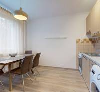 Kitchen in a 2-room apartment with a table and chairs, floor with wooden decor.