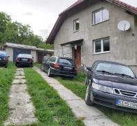 A family house in Orovnica with four cars in front of the garage and a satellite dish.