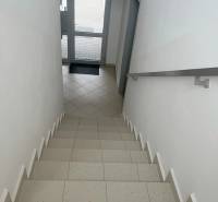 A staircase with tiles leading to the glass doors in a 2-room apartment.