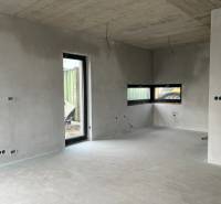 The interior of a family house with concrete walls and large windows, showing incomplete electrical installation.