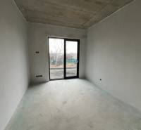 Empty room with a concrete floor and large windows in a family house.