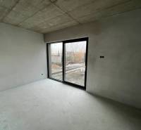 Empty room in a family house with a concrete ceiling and a large window.