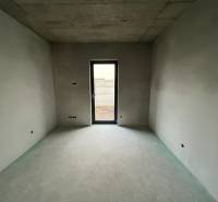 An unfinished room with unplastered walls and a concrete ceiling in a family house.