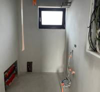 A room in a family house with wiring and a small window, the renovation process is underway.