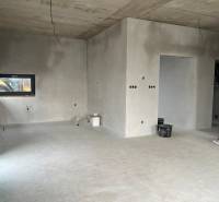 Unfinished interior of a family house with neutral walls and concrete floor.