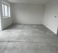 Empty room in a 3-room apartment with a concrete floor and a window.