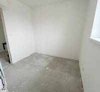 An unfurnished room in a 3-room apartment with white walls and an unfinished floor.