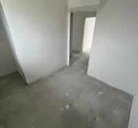 Interior of a 3-room apartment with white walls and unfinished flooring.