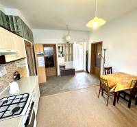 A kitchen in a 2-room apartment with a dining area and a wooden decor floor.