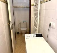 A bathroom with a washing machine and a separate toilet in a 2-room apartment.