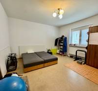 A bedroom with wooden decor, a bed, and a wardrobe in a 2-room apartment with sports equipment.