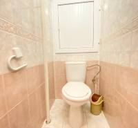 Bathroom in a 2-room apartment with light tiles and a toilet.