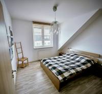 Bedroom in a 3-room apartment with a bed and a wooden decor floor.