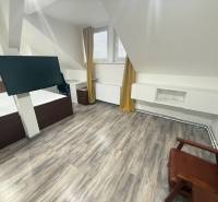 A room with a wooden floor decor, modern television, and furniture in a studio apartment.