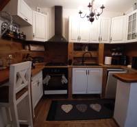 A kitchen in a family house with white cabinets and a wooden decor floor.