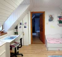 Children's room in a family house with a desk and a bed, floor with wooden decor.
