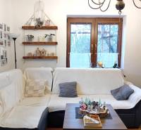 Living room in a family house with a sofa, photo gallery, shelves, and decorations.