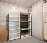 Storage space with two open shelves and cardboard boxes in a 2-room apartment.