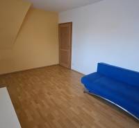 Living room in a 3-room apartment with a wood-patterned floor and a blue couch.