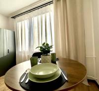 A cozy corner of a studio apartment with a round table and dishes.