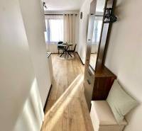 A bright interior with a dining table and wood-decor flooring in a studio apartment.