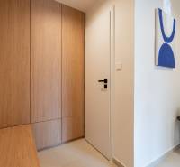 In the 3-room apartment, there is an entrance hall with wooden decor and modern art.