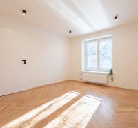 A bright room with white walls and a floor with a wood decor in a 3-room apartment.