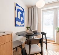 Dining area in a 3-room apartment with a round table and a painting on the wall.