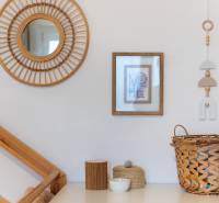 Wooden decorative frame, basket, and mirror on the wall in a 2-room apartment.