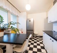 The kitchen with a black and white floor in a 3-room apartment contains a plant and a dining table.