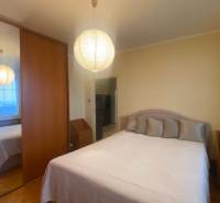 Bedroom in a 3-room apartment with a wardrobe, bed, and floor with a wooden decor.