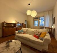 Living room in a two-room apartment with a wooden decor floor and a comfortable sofa.