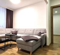 Living room with a comfortable sofa and a wooden-patterned floor in a 3-room apartment.